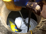 Person in man hole with protection gear on