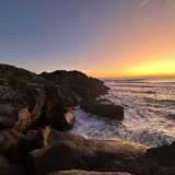 View out at sunset over the ocean from a rocky shore