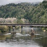Scenic image of a rail bridge crossing a river taken on an overcast day